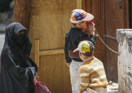 Yemeni boy drinking in a public fountain in the street, Amanat Al-Asemah, Sanaa, Yemen