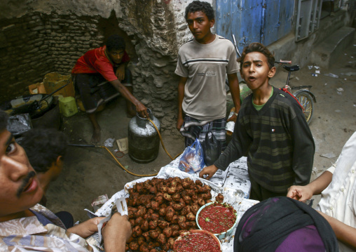 Yemeni men eating street food, Al Hudaydah Governorate, Zabid, Yemen