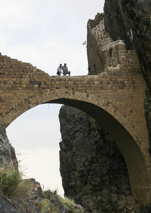 Yemeni men on  Shahara bridge over a rocky gorge, Amran Governorate, Shaharah, Yemen