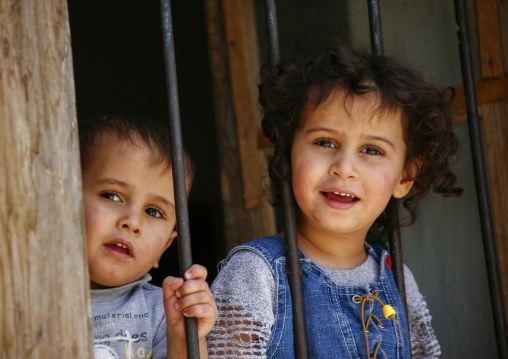 Yemeni girls standing behind a window, Amanat Al-Asemah, Sanaa, Yemen
