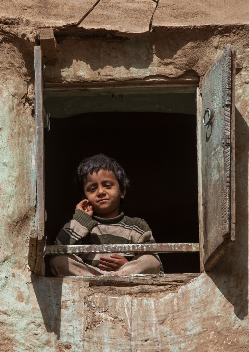 Yemeni boy at the window of a traditional house, Amran Governorate, Amran, Yemen