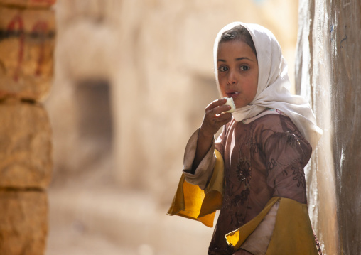 Young yemeni girl Eeating a boiled egg in the street, Amran Governorate, Amran, Yemen