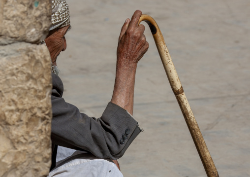 Yemeni man with a cane sit in the street, Amran Governorate, Amran, Yemen