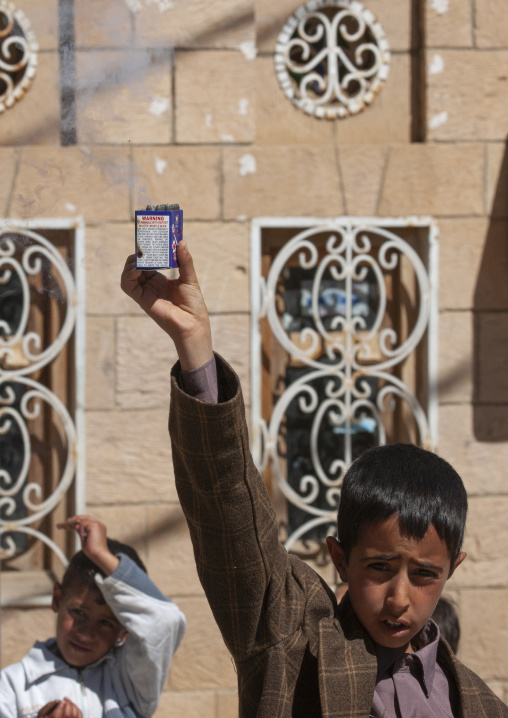 Yemeni boy with a smoke bomb during a wedding, Amran Governorate, Thula, Yemen