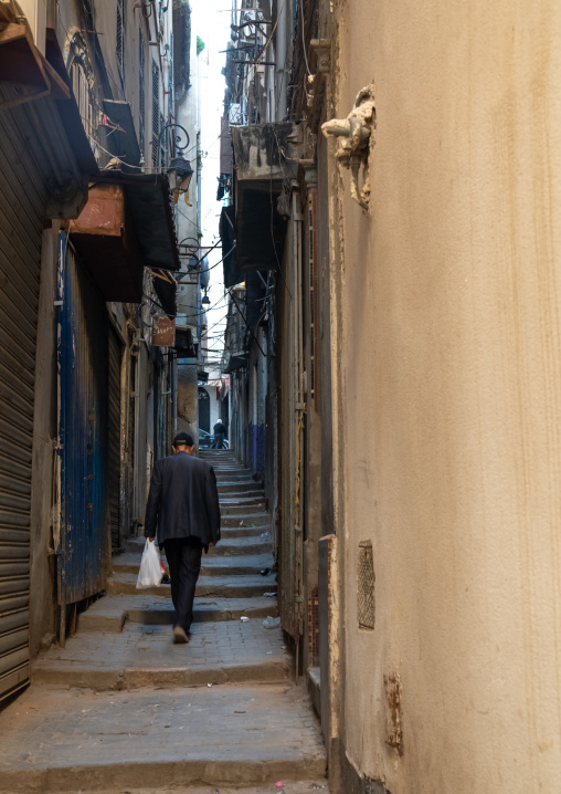 Algerian man walking in a narrow street with stairs, North Africa, Algiers, Algeria