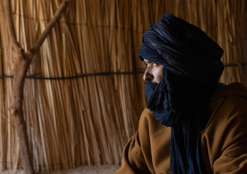 Tuareg man inside his reed house looking away, North Africa, Tamanrasset, Algeria