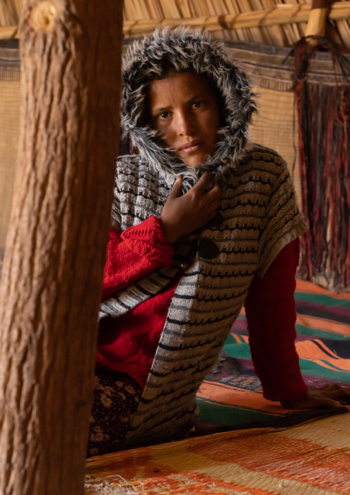 Portrait of a tuareg boy sit inside a reed house, North Africa, Tamanrasset, Algeria