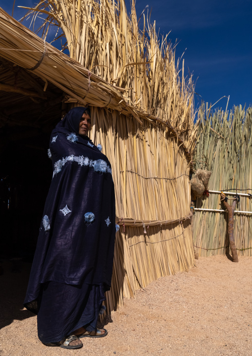 Tuareg woman standing in front of her reed house, North Africa, Tamanrasset, Algeria