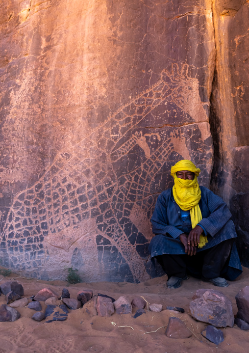 Tuareg near a rock carvings depicting giraffes, Tassili N'Ajjer National Park, Tadrart Rouge, Algeria