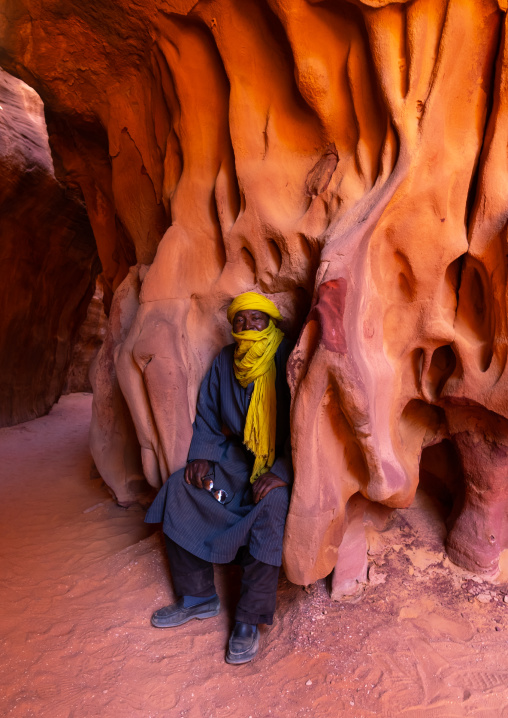 Tuareg sit in a weathered sandstone area, Tassili N'Ajjer National Park, Tadrart Rouge, Algeria