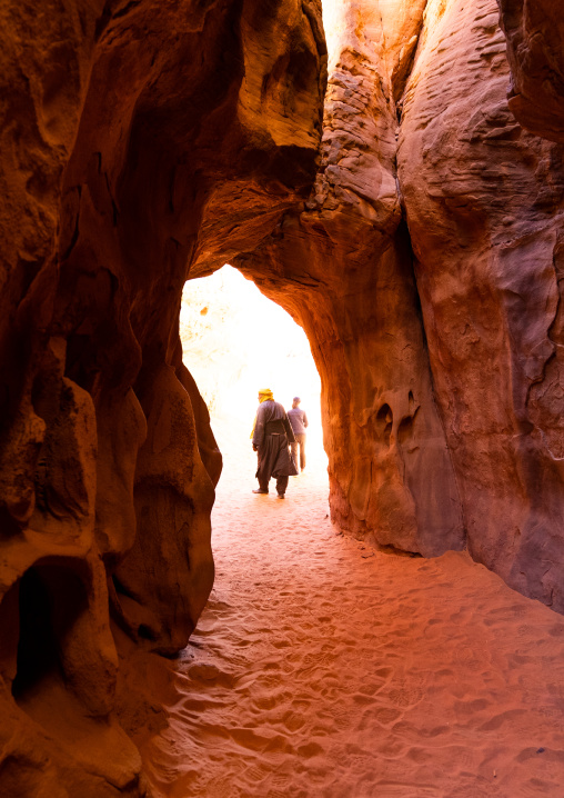 Tourists waliking in weathered sandstone passage, Tassili N'Ajjer National Park, Tadrart Rouge, Algeria