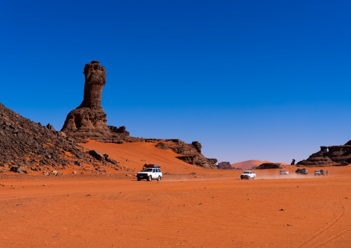 Cars in front of World Cup Rock formation in Sahara desert, Tassili N'Ajjer National Park, Tadrart Rouge, Algeria
