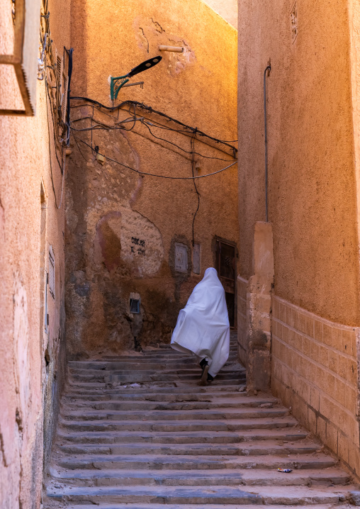Mozabite woman in white haïk in the streets of Ksar El Atteuf, North Africa, Ghardaia, Algeria