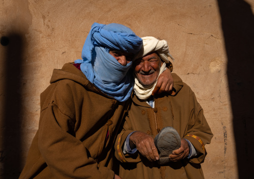 Two men in bournous laughing together in the street, North Africa, Metlili, Algeria