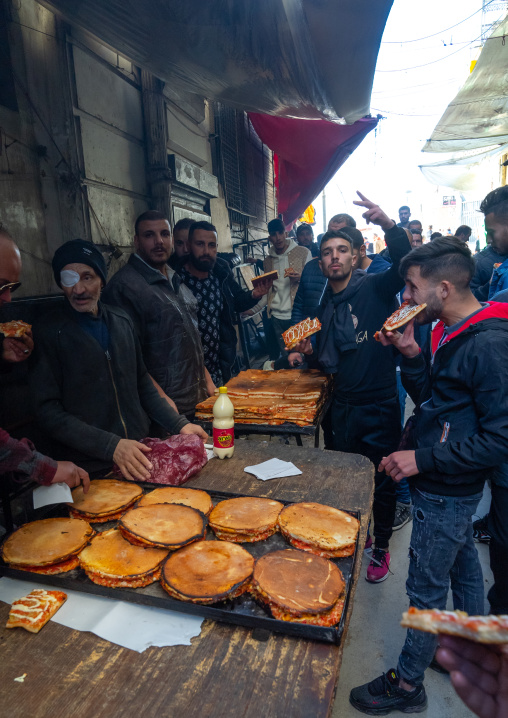 Algerian people buying pizzas in Souk El Ghezel, North Africa, Constantine, Algeria