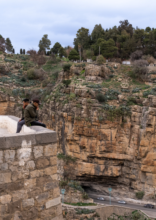 Algerian men sit on the edge of the canyon, North Africa, Constantine, Algeria