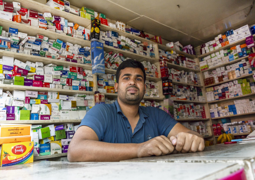 Bangladeshi pharmacist at the desk of his pharmacy, Dhaka Division, Dhaka, Bangladesh