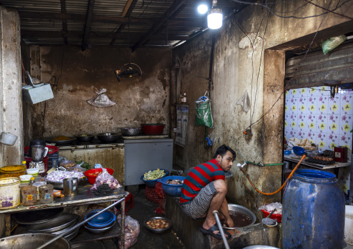 Bangladeshi man cooking in a restaurant kitchen in Korail slum, Dhaka Division, Dhaka, Bangladesh