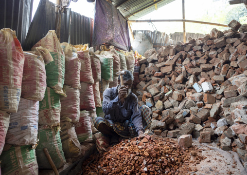 Worker crashing stones with a hammer in a workshop, Dhaka Division, Dhaka, Bangladesh