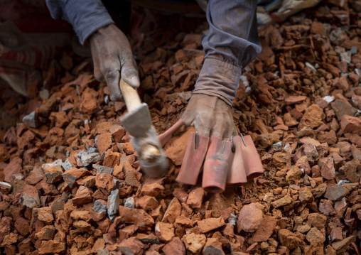 Worker crashing stones with a hammer in a workshop, Dhaka Division, Dhaka, Bangladesh