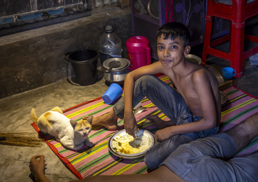 Bangladeshi boy with his cat inside his home, Dhaka Division, Dhaka, Bangladesh