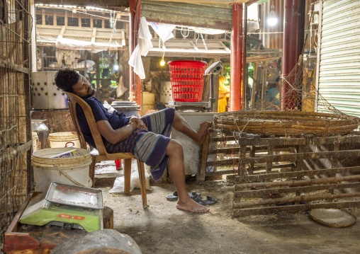 Bangladeshi man sleeping on a chair inside the market, Dhaka Division, Dhaka, Bangladesh