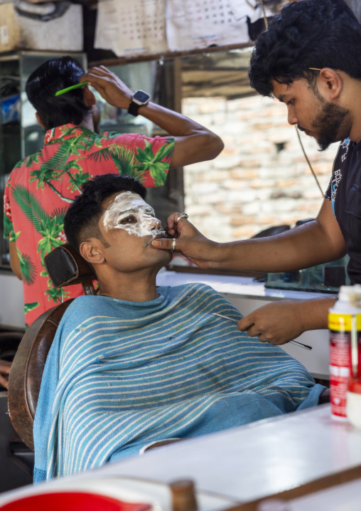 Bangladeshi man having facial shaving at barber, Dhaka Division, Dhaka, Bangladesh