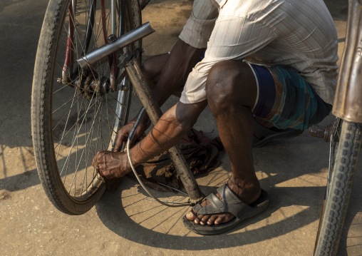 Bangladeshi man filling bicycle tires with air pump, Dhaka Division, Dhaka, Bangladesh