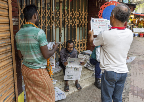 Bangladeshi men reading newspaper in the street, Dhaka Division, Dhaka, Bangladesh