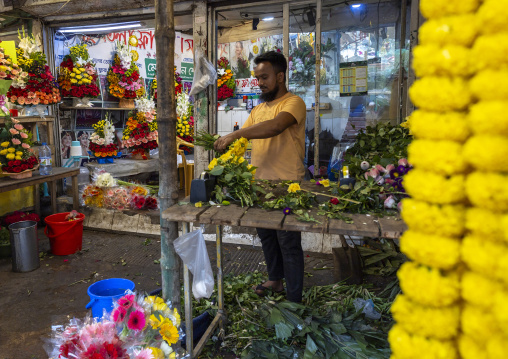 Bangladeshi man selling garland flowers at flower market, Dhaka Division, Dhaka, Bangladesh