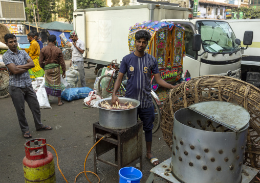 Bangladeshi men cutting chickens at Kawran bazar, Dhaka Division, Dhaka, Bangladesh