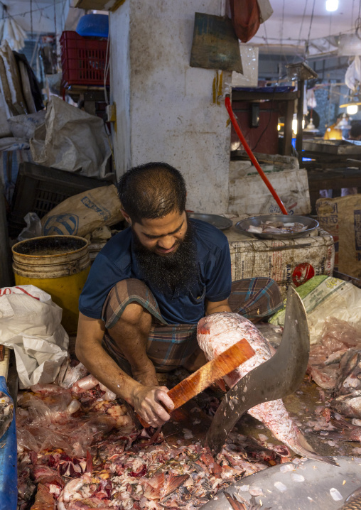 Bangladeshi man removing fish scales at fish market, Dhaka Division, Dhaka, Bangladesh