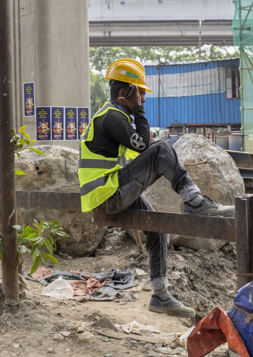 Bangladeshi construction worker calling on phone, Dhaka Division, Dhaka, Bangladesh