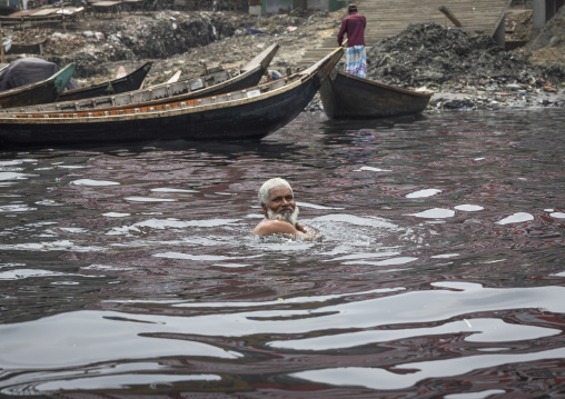 Bangladeshi senior man swimming in Buriganga river, Dhaka Division, Keraniganj, Bangladesh