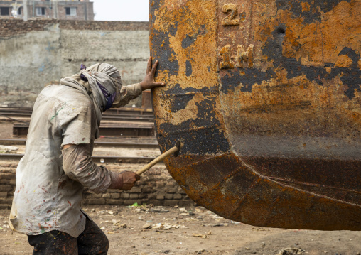 Worker at Dhaka Shipyard removing rust, Dhaka Division, Keraniganj, Bangladesh