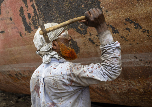 Worker at Dhaka Shipyard removing rust, Dhaka Division, Keraniganj, Bangladesh