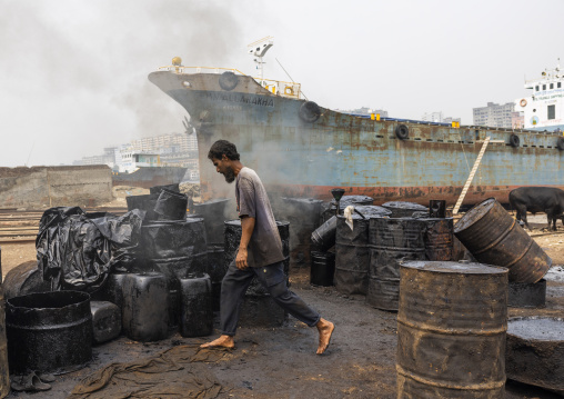 Bangladeshi man burning asphalt at Dhaka Shipyard, Dhaka Division, Keraniganj, Bangladesh