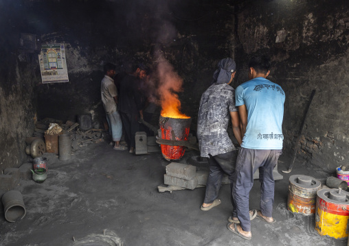 Bangladeshi workers putting molten steel into a mold at Dhaka Shipyard, Dhaka Division, Keraniganj, Bangladesh