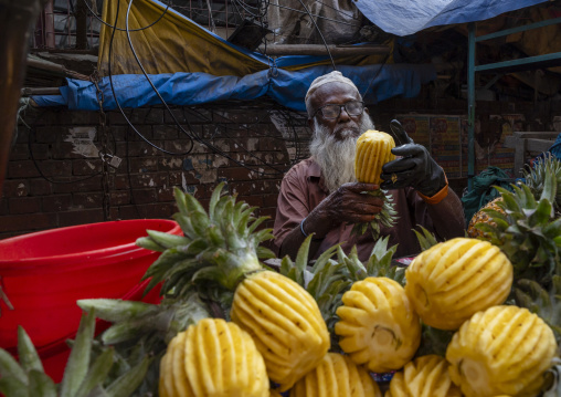 Bangladeshi old man peeling pineappeles, Dhaka Division, Dhaka, Bangladesh