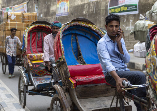 Rickshaw driver on the phone in the traffic, Dhaka Division, Dhaka, Bangladesh