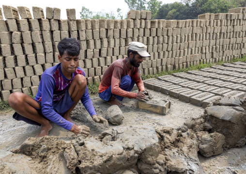 Worlers putting clay in a brick mould, Sylhet Division, Bahubal, Bangladesh