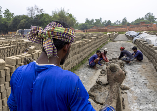 Worlers putting clay in a brick mould, Sylhet Division, Bahubal, Bangladesh