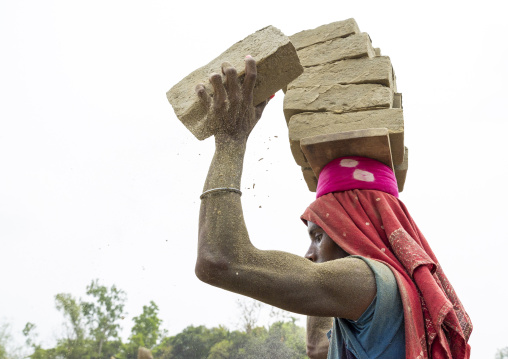 A bangladeshi man carries bricks on his head at a brick factory, Sylhet Division, Bahubal, Bangladesh