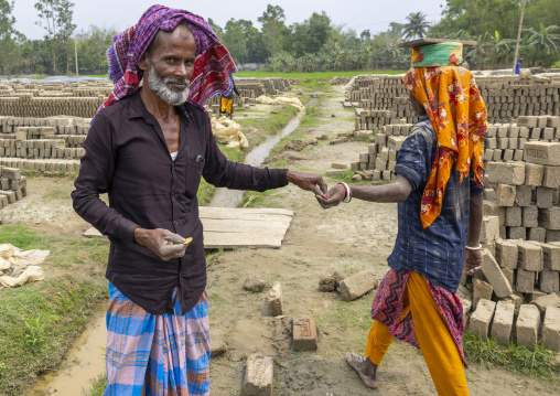 Supervisor paying a worker at a brick factory, Sylhet Division, Bahubal, Bangladesh