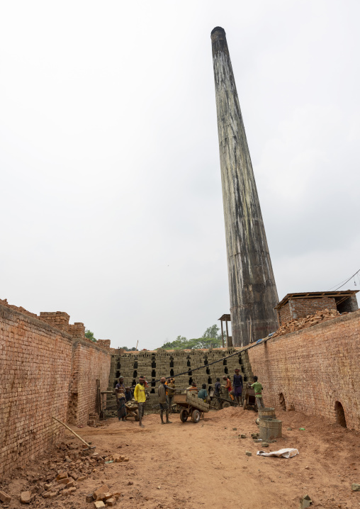 Workers standing in the entrance of an oven of a brick factory, Sylhet Division, Bahubal, Bangladesh