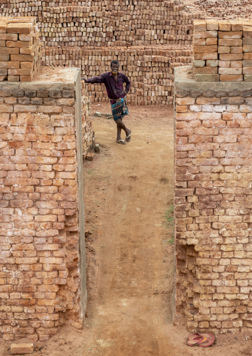 Worker standing in the entrance of an oven of a brick factory, Sylhet Division, Bahubal, Bangladesh