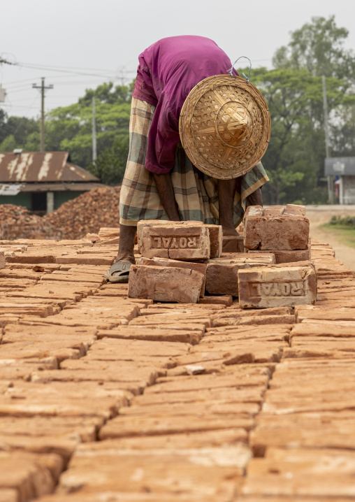 A bangladeshi man carries bricks on his head at a brick factory, Sylhet Division, Bahubal, Bangladesh