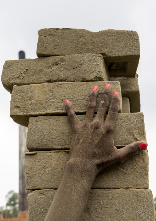 Hijra carrying bricks on his head at a brick factory, Sylhet Division, Bahubal, Bangladesh