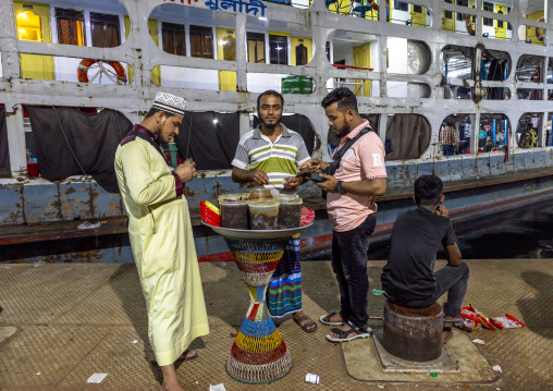 Passengers eating in front of the ferry at Sadaghat Launch Terminal, Dhaka Division, Dhaka, Bangladesh