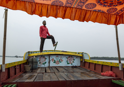 Bangladeshi man rowing a boat with his foot in Sundarbans, Barisal Division, Banaripara, Bangladesh